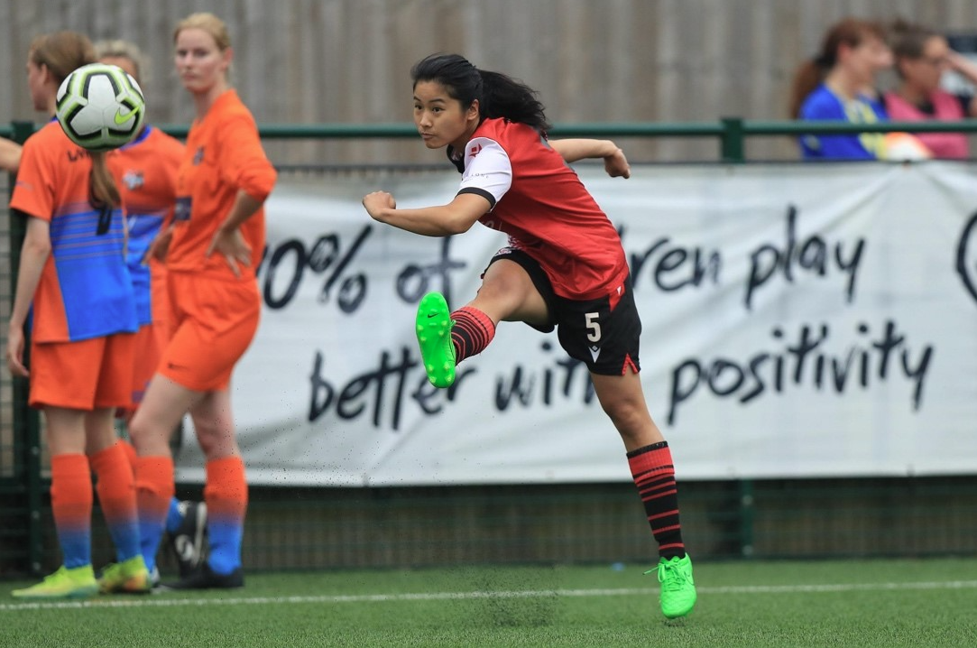 Woman kicking football